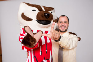 Gabriel Neves holding up "W" sign with Bucky Badger